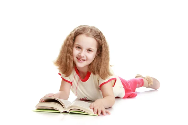 Blondes Teenie-Mädchen liegt auf dem Boden und liest ein Buch — Stockfoto
