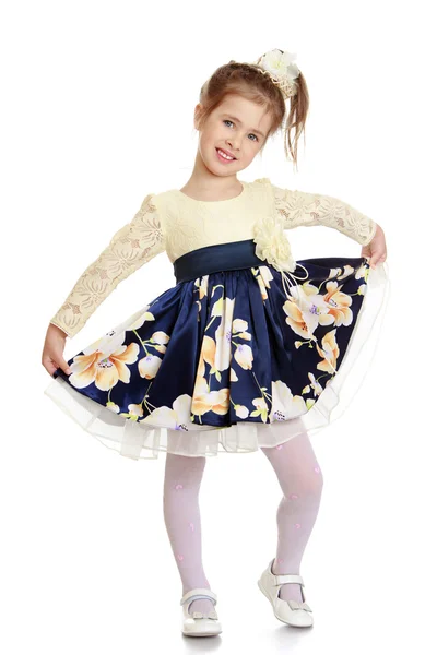 Mooie kleine meisje bedrijf vloeren jurk — Stockfoto