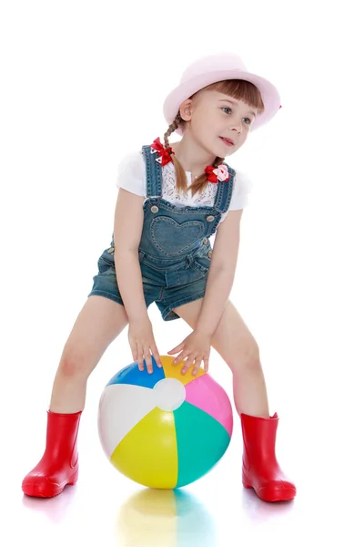 Girl in a short denim overalls, hat and rubber boots — Stock Photo, Image