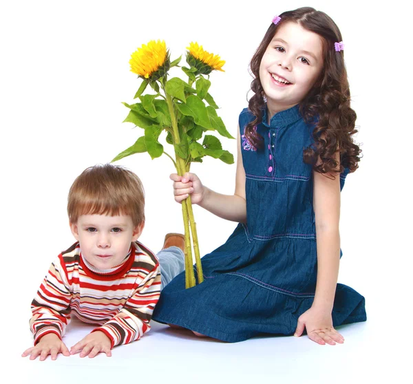 Hermano pequeño y hermana con un ramo de girasoles — Foto de Stock