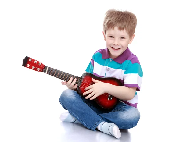 Gülümseyen küçük çocuk gitar çalmak — Stok fotoğraf