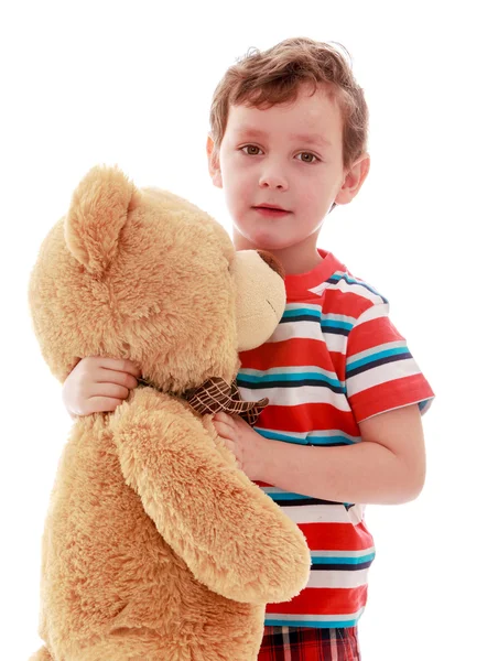 Niño lleva en sus manos un osito de peluche — Foto de Stock