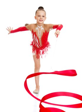 Young gymnast performs exercises with the tape