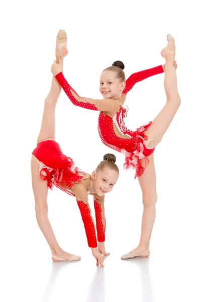 Girls gymnasts perform a beautiful element — Stockfoto