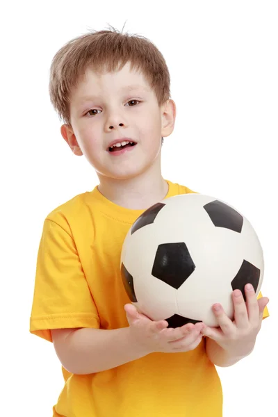 Niño alegre con una pelota de fútbol en sus manos — Foto de Stock