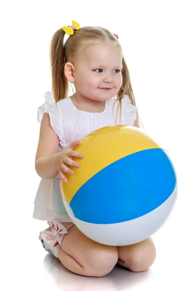 Schöne kleine Mädchen auf den Knien mit dem Ball in seinen Händen — Stockfoto