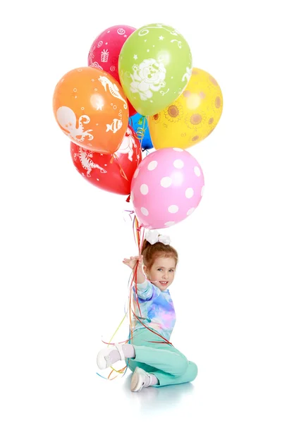 Girl in kindergarten is holding a bunch of balloons — Stok fotoğraf
