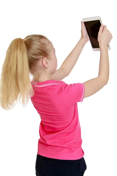 Teen blonde looks at the screen of a tablet , close-up — Stock Photo, Image