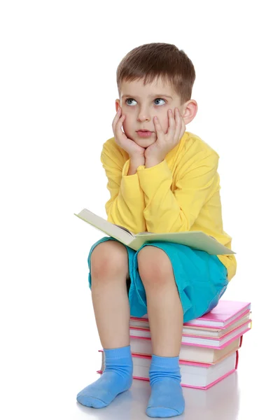 Маленький хлопчик мріє прочитати книгу — стокове фото