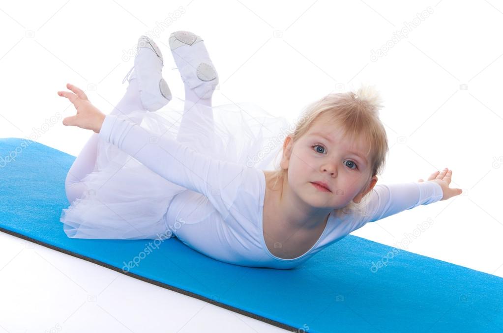 Girl contortionist lies on the gymnastic Mat
