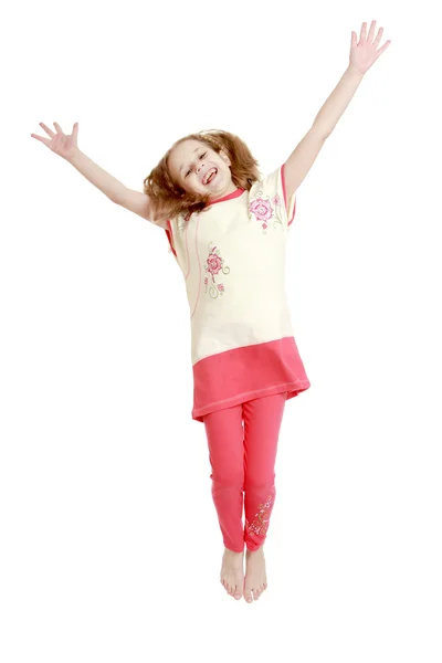 Joyful girl jumping with hands wide apart — Stock Photo, Image