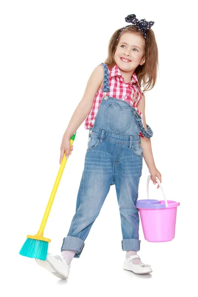 Funny funny little girl in denim overalls holding — Stockfoto