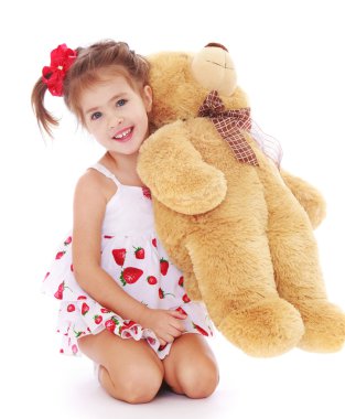 Cute little girl in a light white dress is holding on his knees 