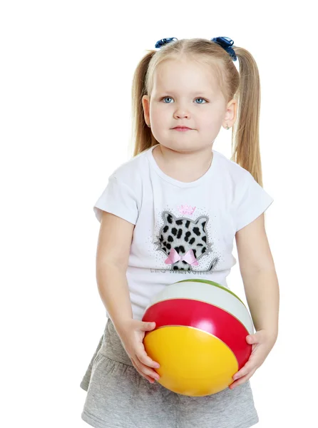 Cute chubby little girl with long blonde tails holds up a the ba — Stok fotoğraf