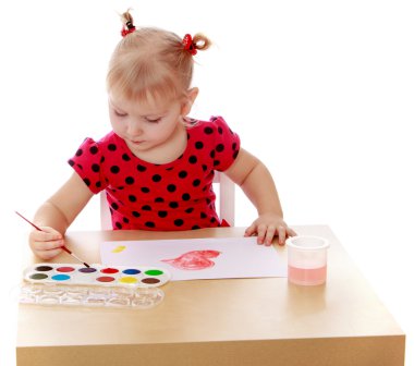 Blonde little girl with pigtails in a red polka dot dress sittin