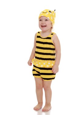Very little girl in a striped t-shirt and shorts standing on the