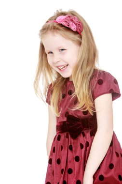 Cute little blond Caucasian girl in a fluffy dress with polka do