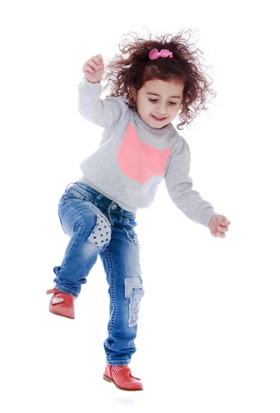 Fun little curly girl fun jumps — Zdjęcie stockowe