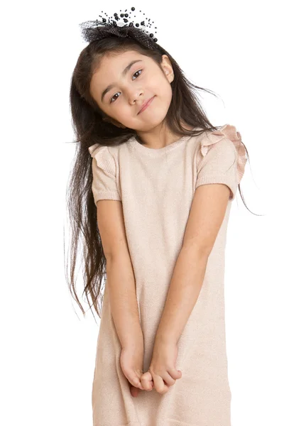 Stylish little dark-haired girl in a beige dress gently looking — Stock fotografie