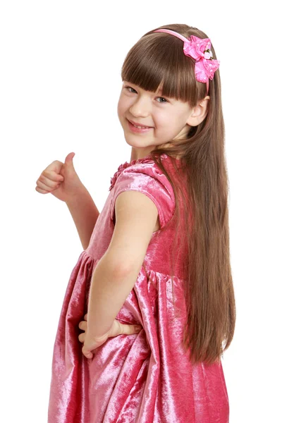 Beautiful girl with long, lush hair and short bangs in pink velvet — Stockfoto