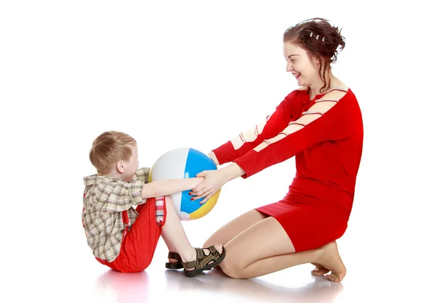 Mother and son playing with a ball sitting on the floor — ストック写真