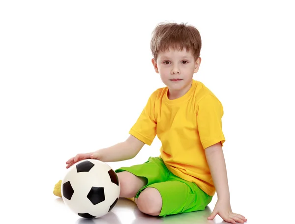 Hermoso niño de pelo rubio con una camisa amarilla y pantalones cortos verdes — Foto de Stock