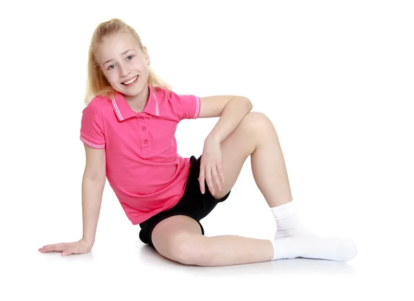 Girl in shorts sitting on the floor — Stok fotoğraf