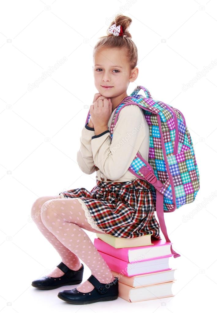 Girl sitting on rows of books
