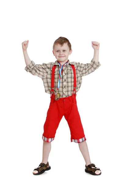Мальчик в длинных красных шортах — стоковое фото