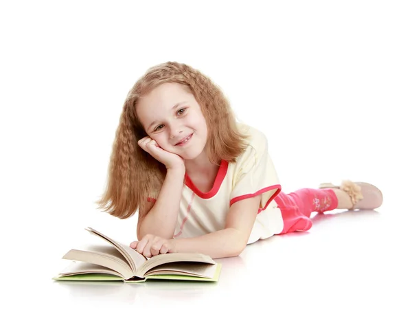 The girl lies on the floor and reading a book — Stock fotografie