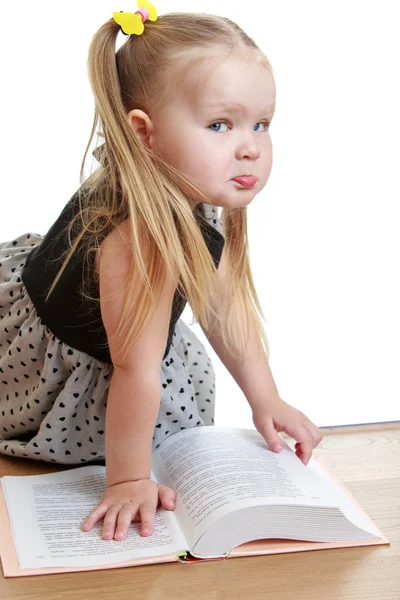 Liten flicka läser en bok på golvet — Stockfoto