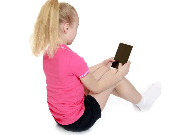 The girl looks at the screen of a smartphone — Stock Photo, Image