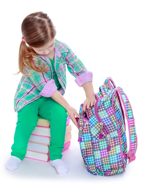 Schoolgirl examines a backpack — Stock fotografie