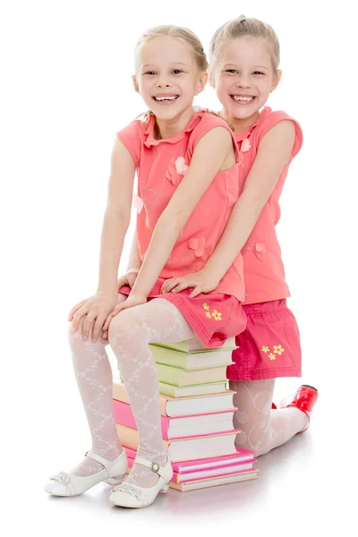 Two sisters sitting on the books — ストック写真