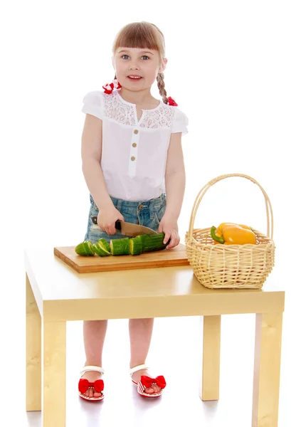 Girl cuts a cucumber — Stock Photo, Image
