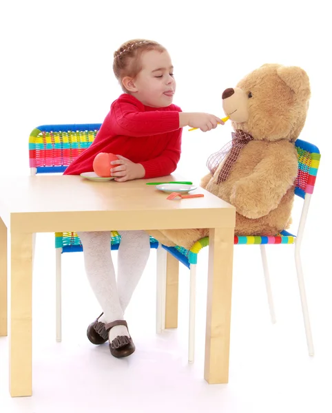 Klein meisje spelen met een teddybeer — Stockfoto
