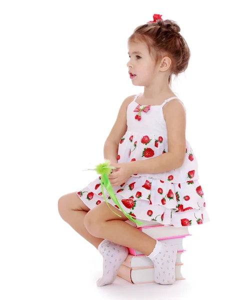 Girl sitting on books — Stock Photo, Image