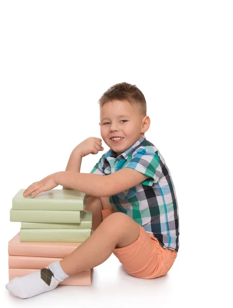 Ребенок обнимает стопку книг — стоковое фото