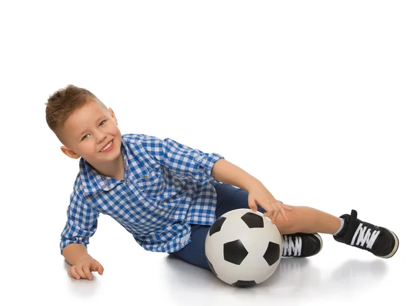 Le garçon roule le ballon de foot — Photo