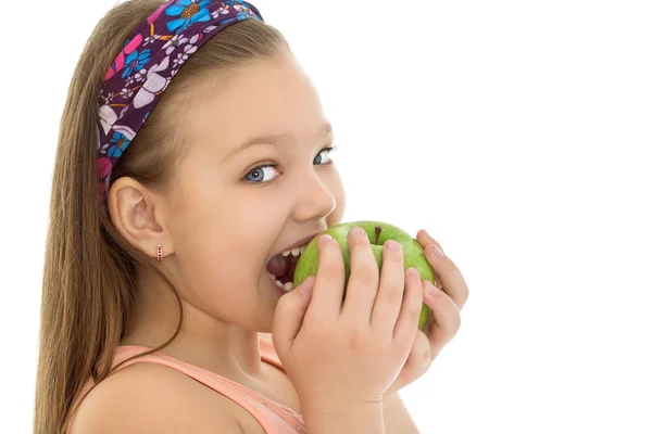 Das Mädchen beißt in den Apfel — Stockfoto