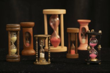 Siyah üzerine izole edilmiş renkli kum saatleri