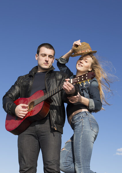 Happy couple playing acoustic guitar 