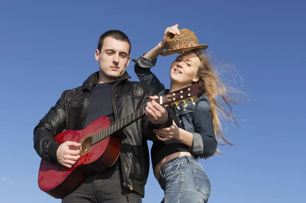 Muž, hrál na akustickou kytaru a usmívající se žena sundala klobouk — Stock fotografie