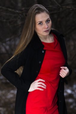 Kırmızı elbise ve siyah ceket ayakta kış parkta genç çekici kadın