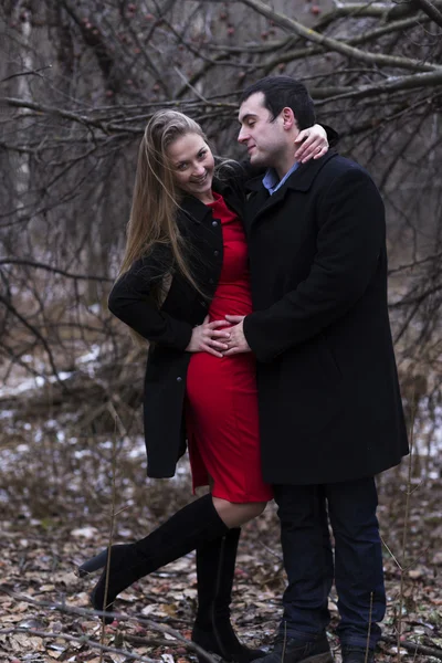 Ung man kramas med ung kvinna i röd klänning — Stockfoto