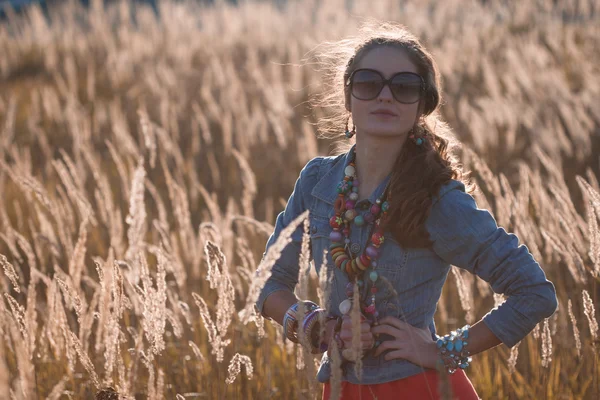 Стильная девушка на поле в солнечных лучах — стоковое фото