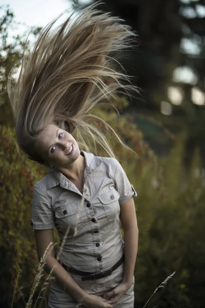 Muchacha atractiva moviendo el pelo largo hasta — Foto de Stock