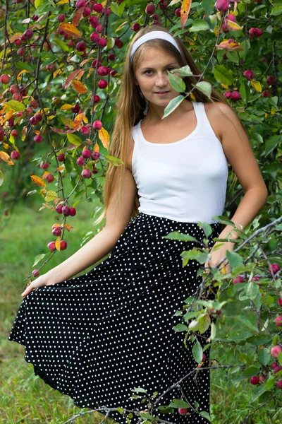 Hermosa chica posando bajo el manzano a la cámara — Foto de Stock