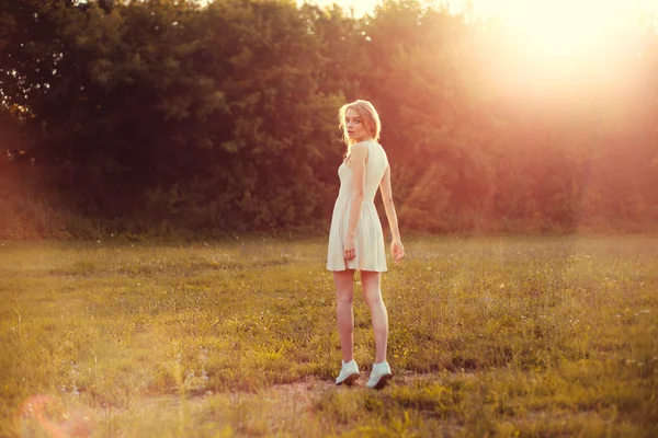 Girl in the park in a white dress on a sunny day — Stock Photo, Image