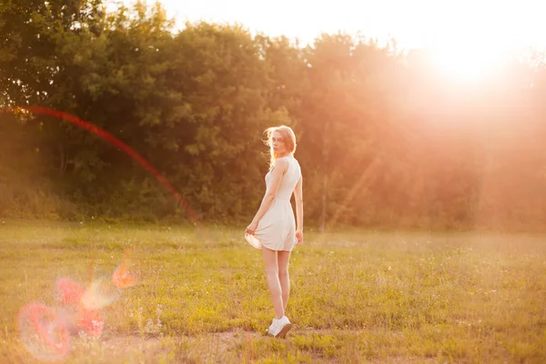 Κορίτσι στο πάρκο σε ένα λευκό φόρεμα σε μια ηλιόλουστη ημέρα — Φωτογραφία Αρχείου